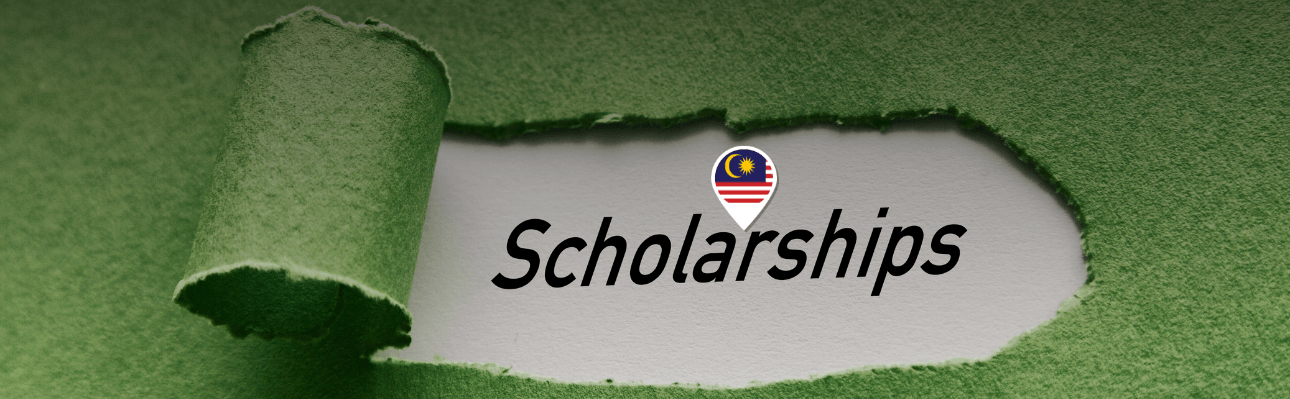 a wide, horizontal banner with a textured green background that resembles torn paper. There's a central, irregularly-shaped, torn white area that reveals the word "Scholarships" in a bold, black font. Just above this word, there is a circular emblem with a design that appears to be the flag of Malaysia, indicating that the scholarships may pertain to or be offered by a Malaysian entity.